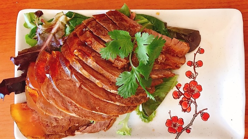 Sliced braised beef with fresh cilantro garnish