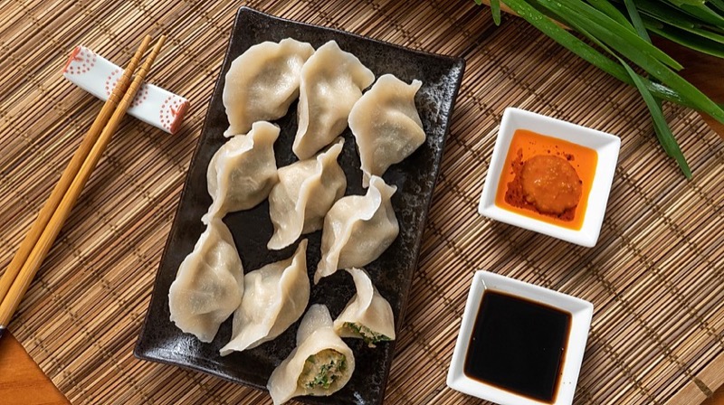 Overhead view of handmade boiled dumplings with dipping sauces