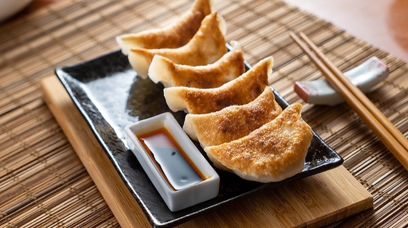 Golden pan-fried potstickers with soy dipping sauce