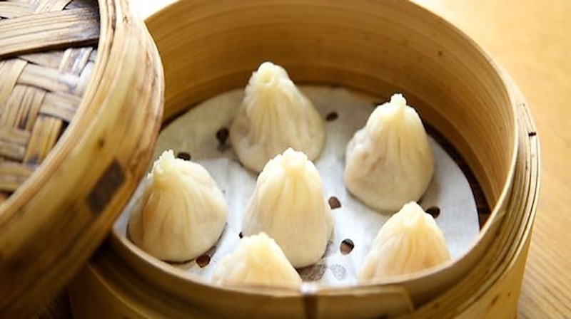 Delicate steamed soup dumplings in bamboo steamer